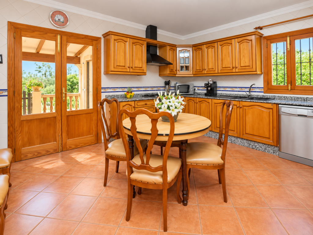 Cocina totalmente equipada con zona de comedor en una villa vacacional en Lloseta, Mallorca, ideal para estancias en familia.