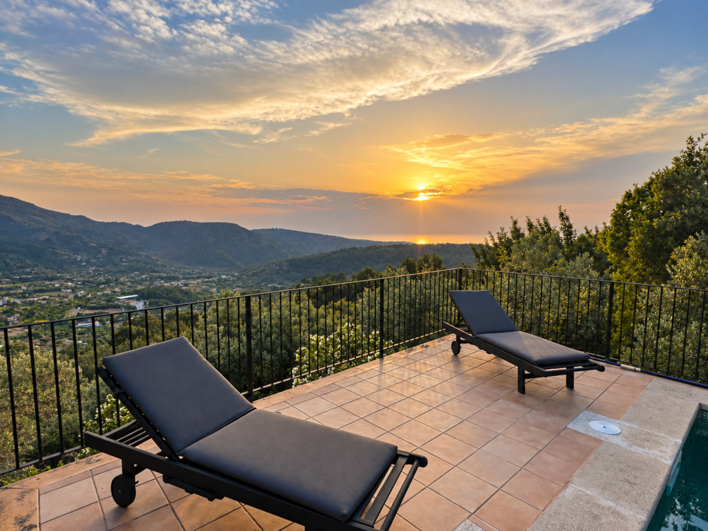 Terraza con tumbonas y vistas panorámicas al atardecer sobre el valle de Sóller y la Serra de Tramuntana en Mallorca.