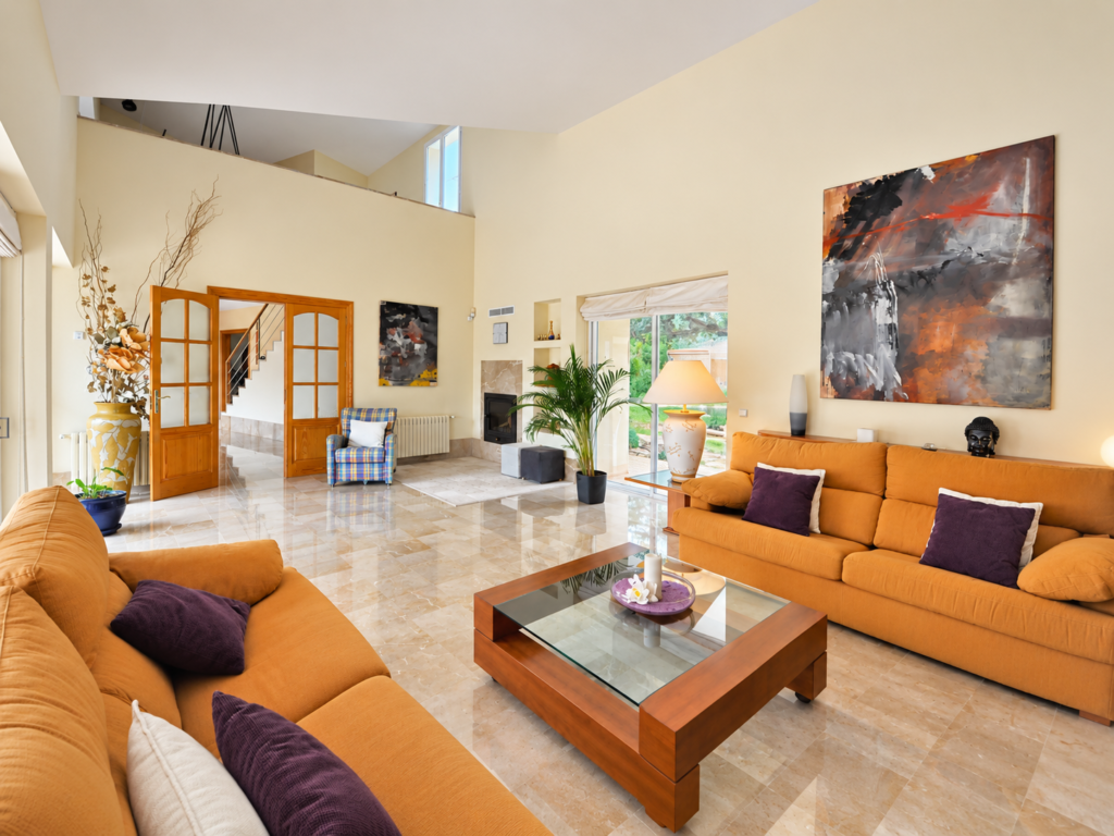 Salón amplio y luminoso con sofás y grandes ventanales en una casa vacacional premium en Bunyola, Mallorca.