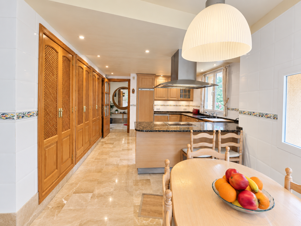 Cocina totalmente equipada con zona de comedor en una casa vacacional para familias y grupos en Bunyola, Mallorca.